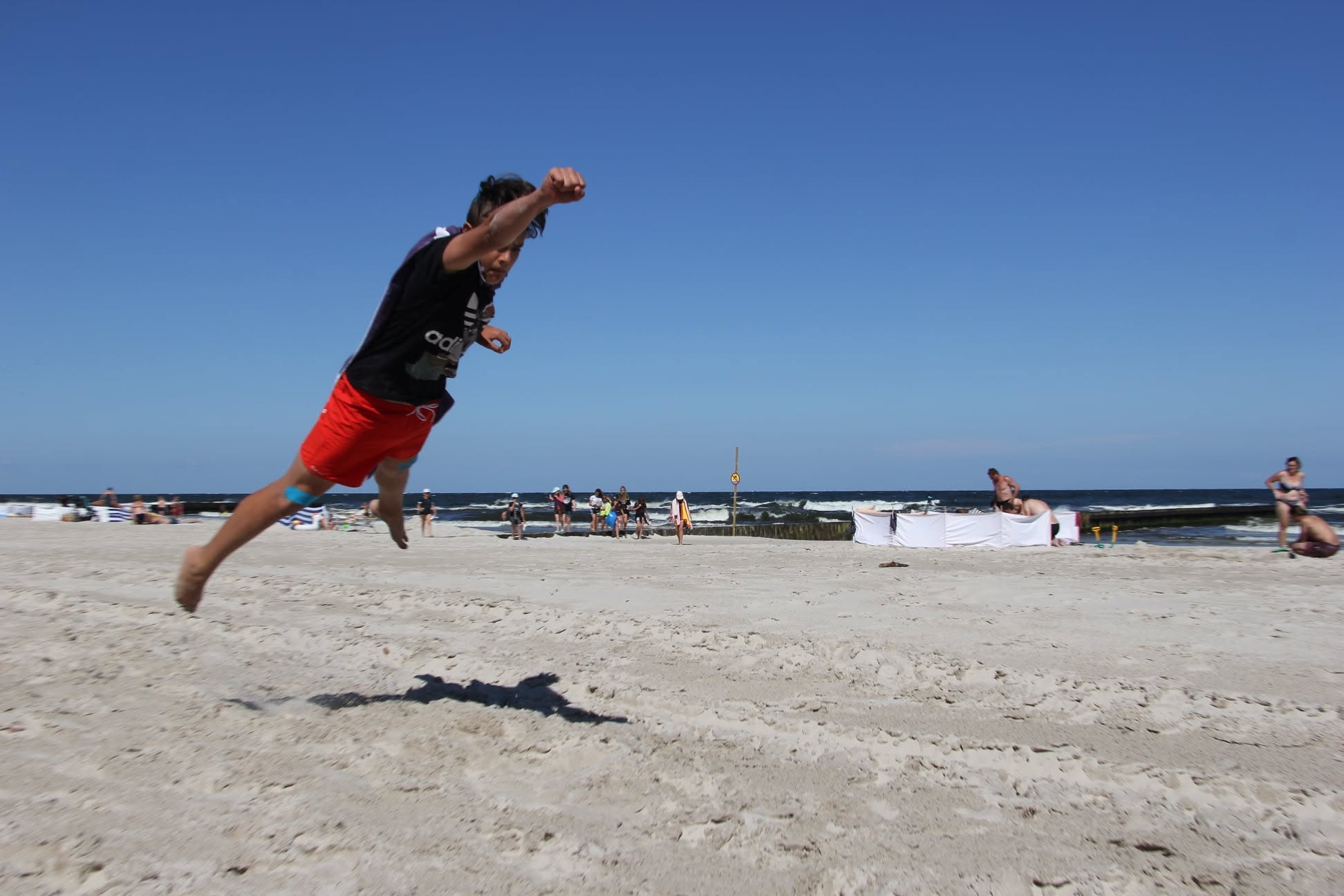 Uczestnik skaczący na plaży podczas zajęć sportowych