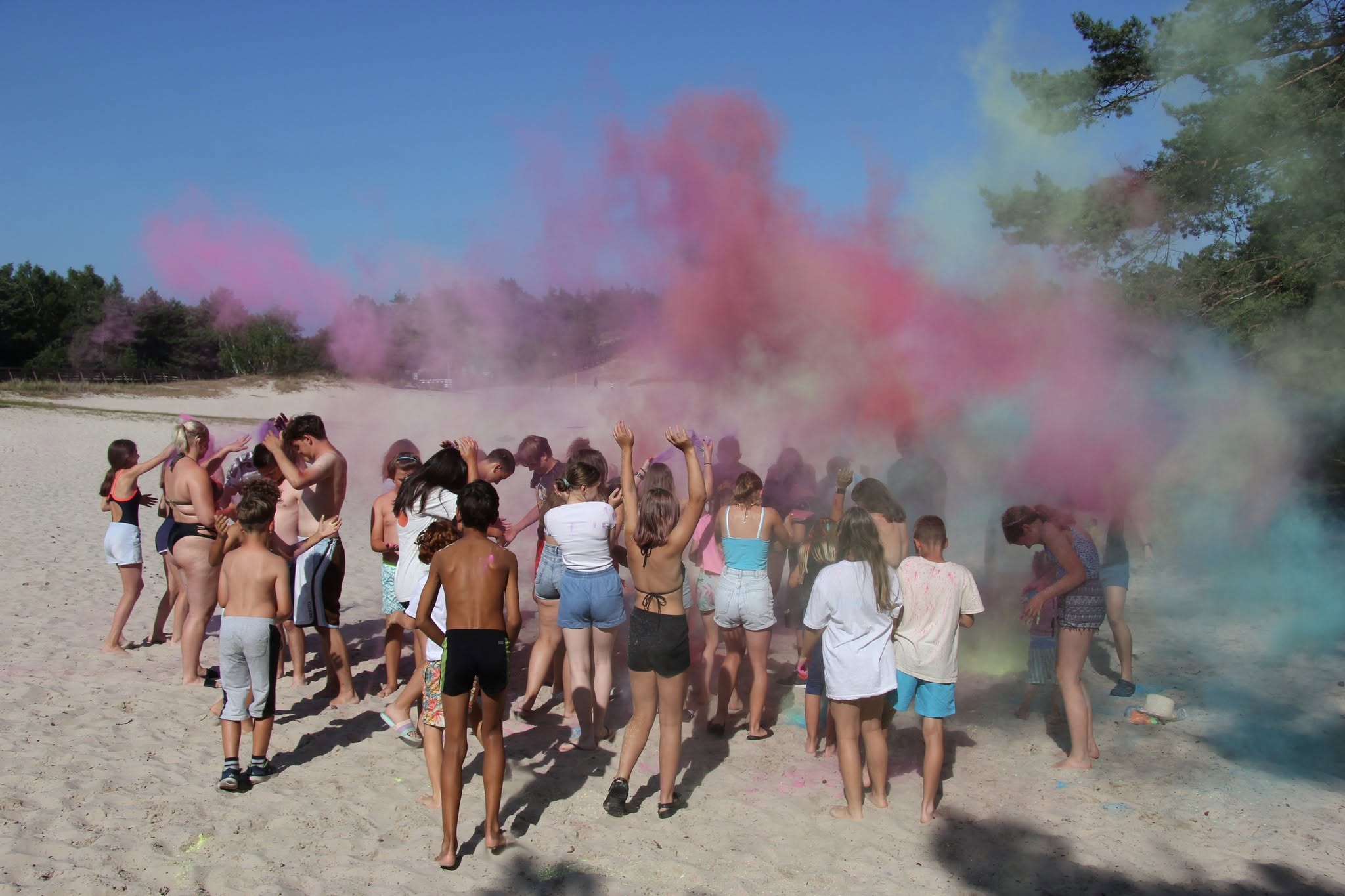 Zabawa z kolorowymi proszkami holi na plaży