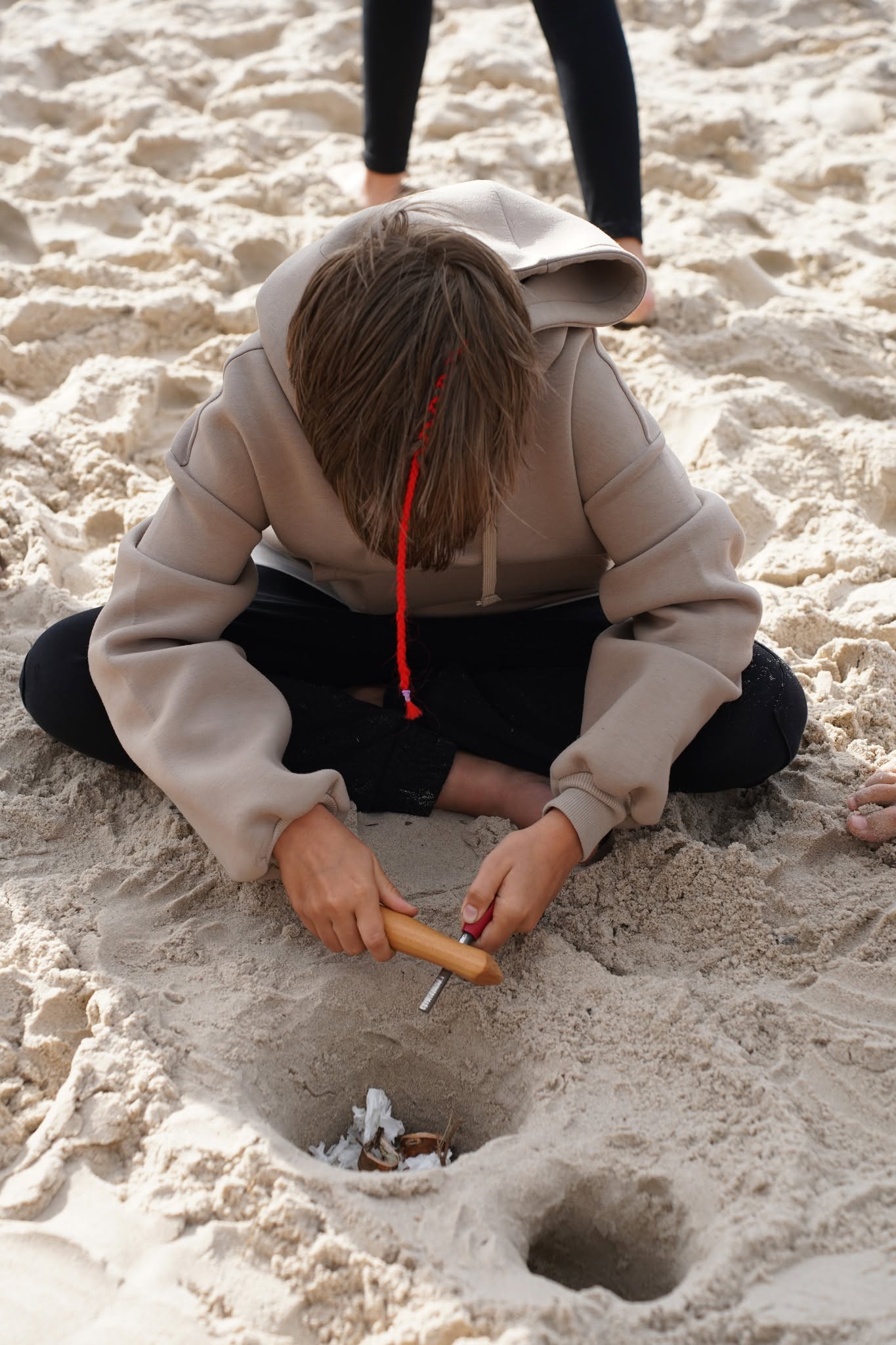 Nauka krzesania ognia podczas zajęć survivalowych na plaży