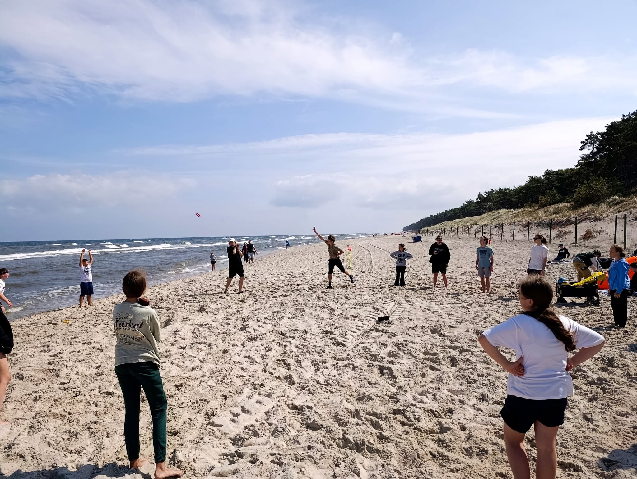 Uczestnicy grają w frisbee na plaży nad Bałtykiem